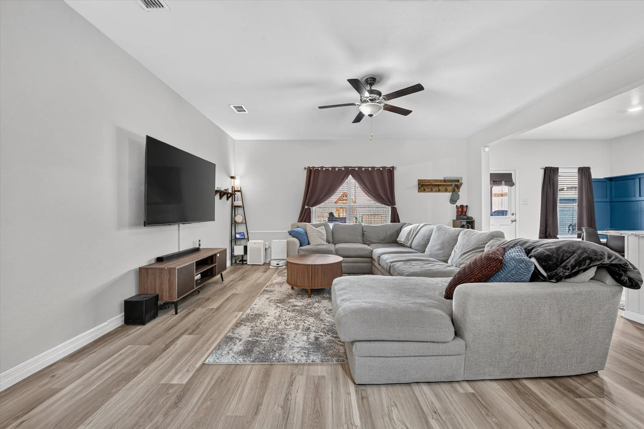 Wood-finish flooring throughout, ceiling fan with integrated lighting, and recessed ceiling lighting