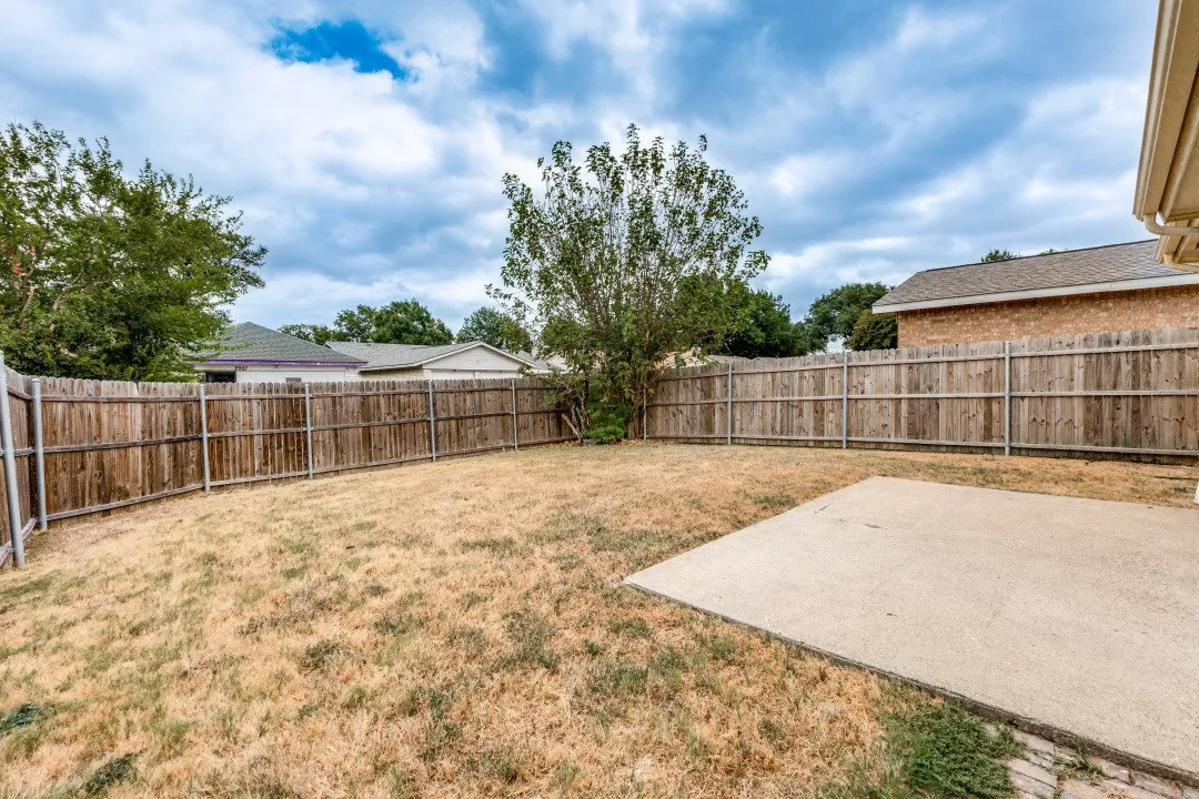 Private backyard featuring a concrete patio and wood fencing