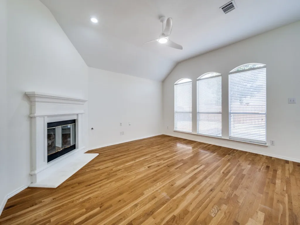 Main living room with gas fireplace and picture windows looking out over the backyard.