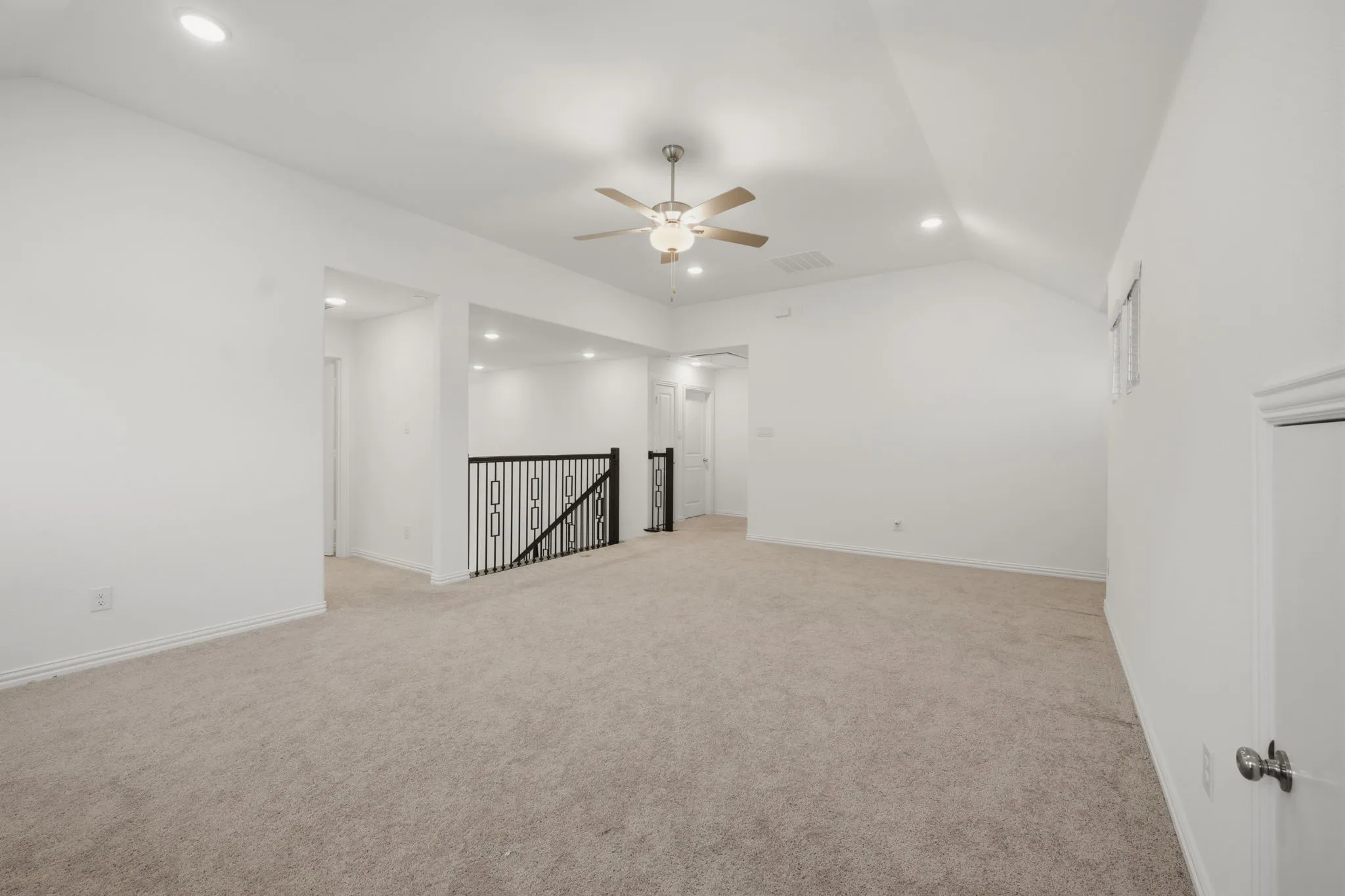 Carpeted living area with a vaulted ceiling, recessed lighting, and a ceiling fan