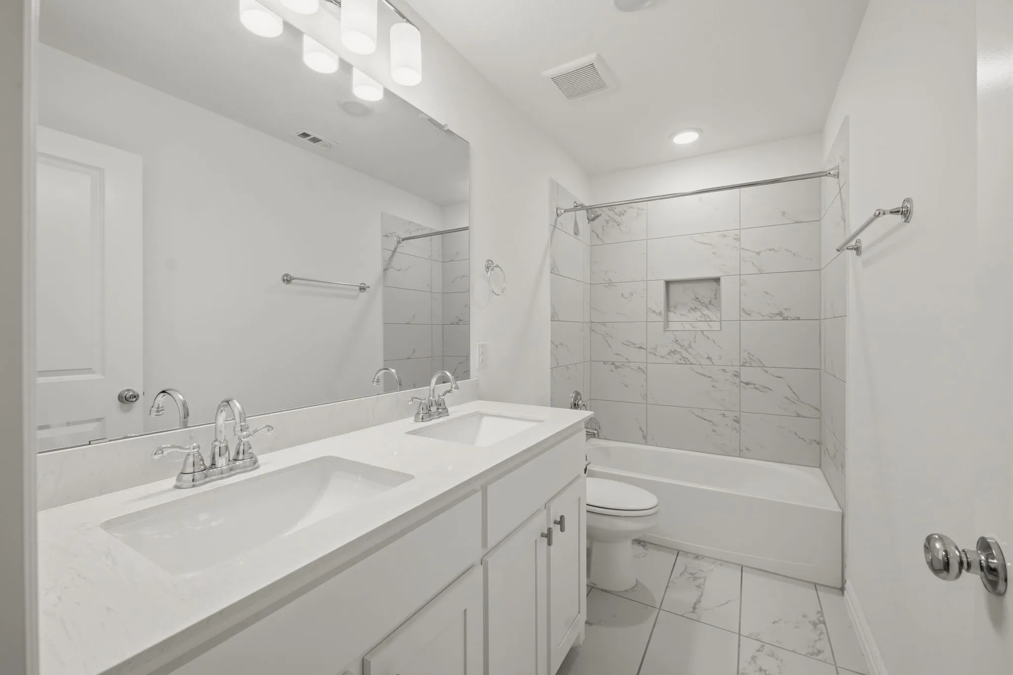 Dual vanity with undermount sinks, chrome fixtures, and stone-finish countertop