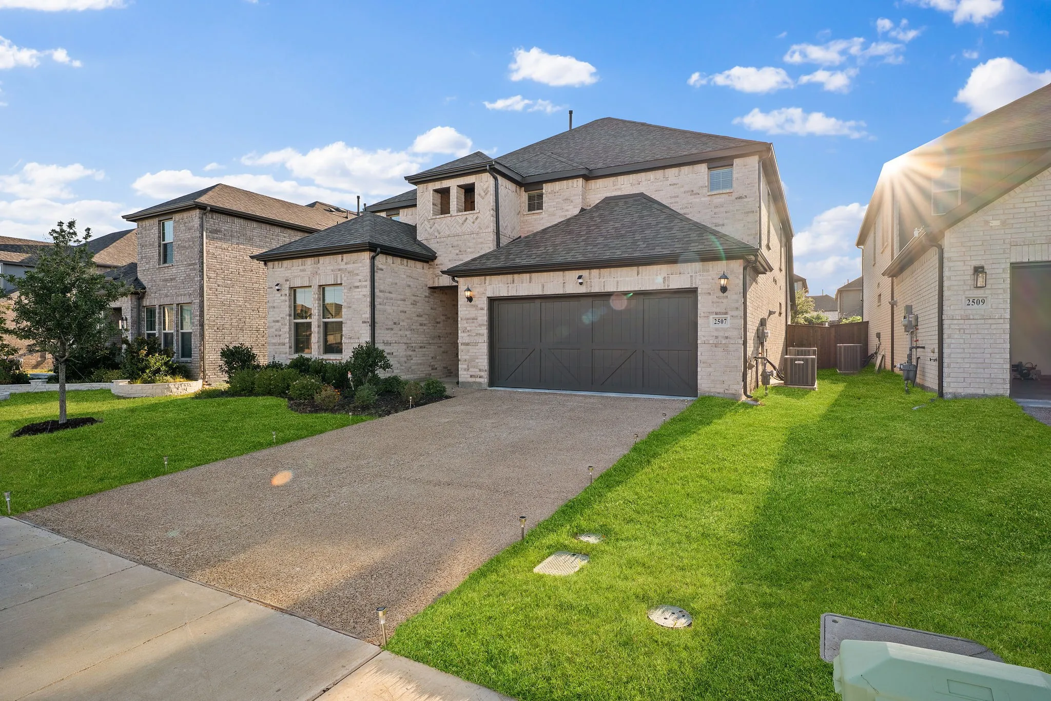 Light-colored brick exterior with dark trim and a two-car garage