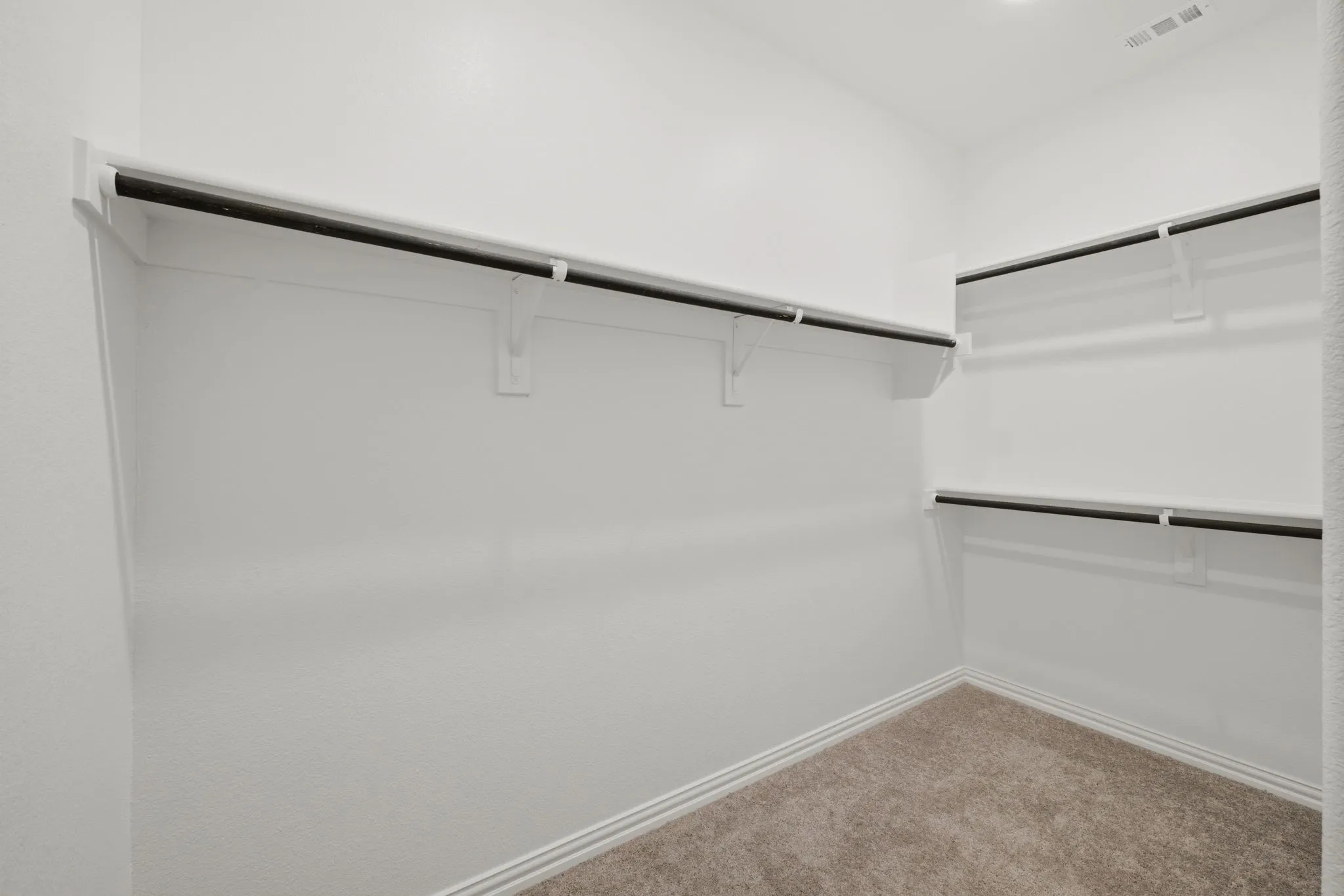 Built-in shelving with hanging rods and carpet flooring