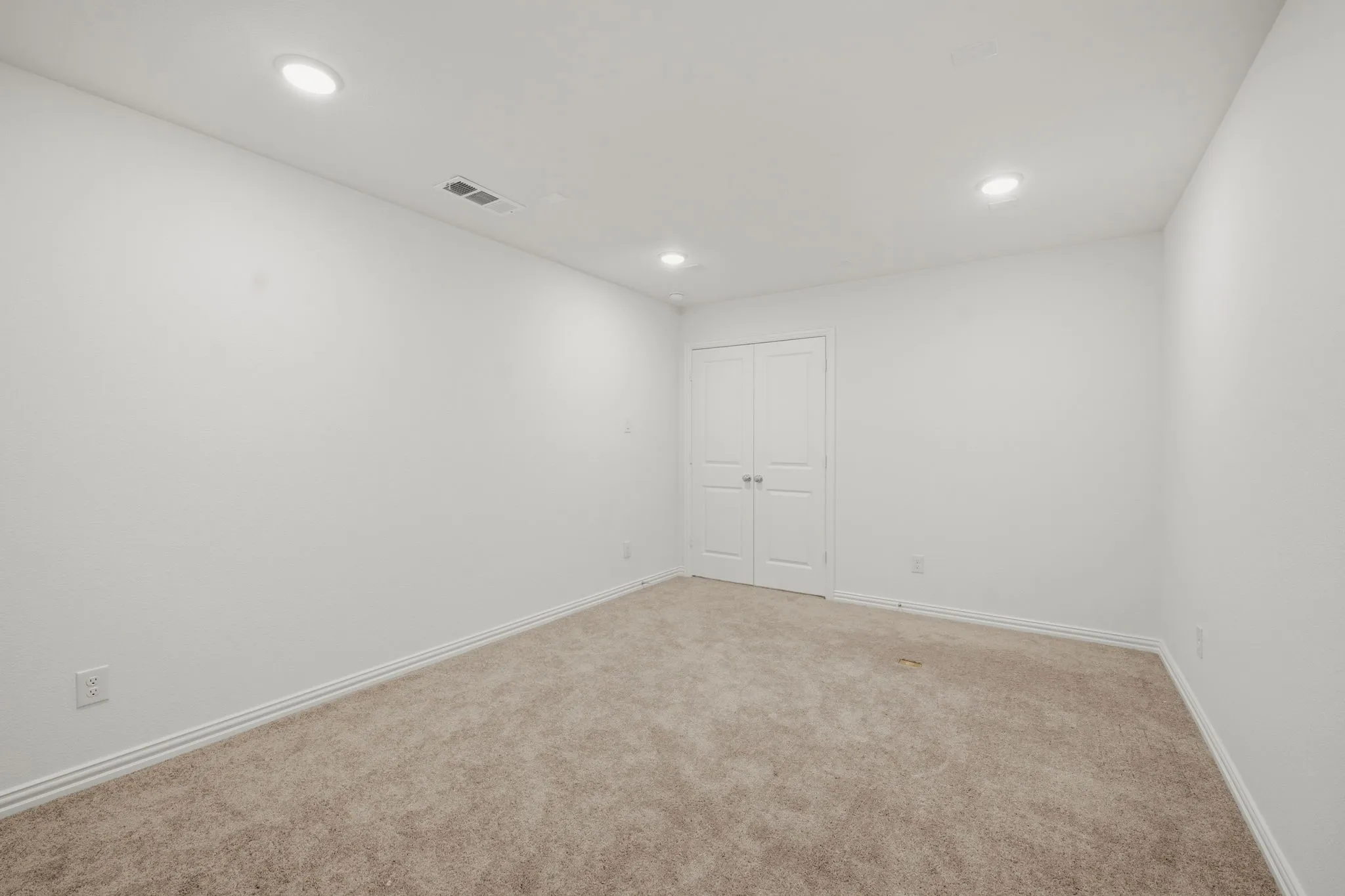 Neutral wall paint, carpeted flooring, recessed lighting, and double bi-fold doors