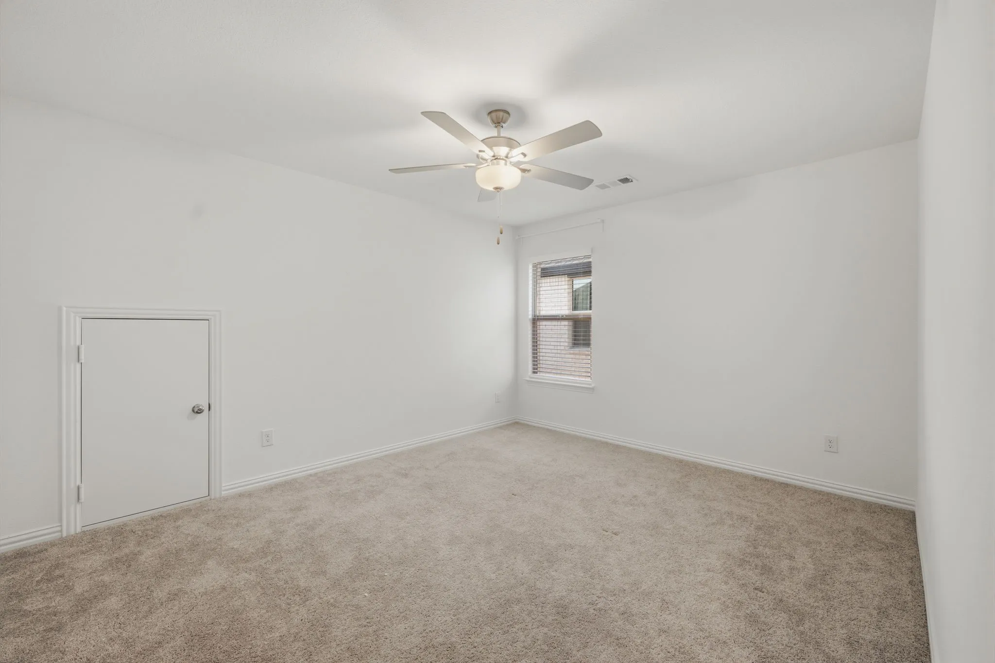 Neutral-toned carpeting, white walls, and a ceiling fan with integrated lighting