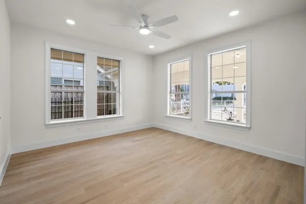 Recessed lighting, ceiling fan, wood-finish flooring, and multiple windows