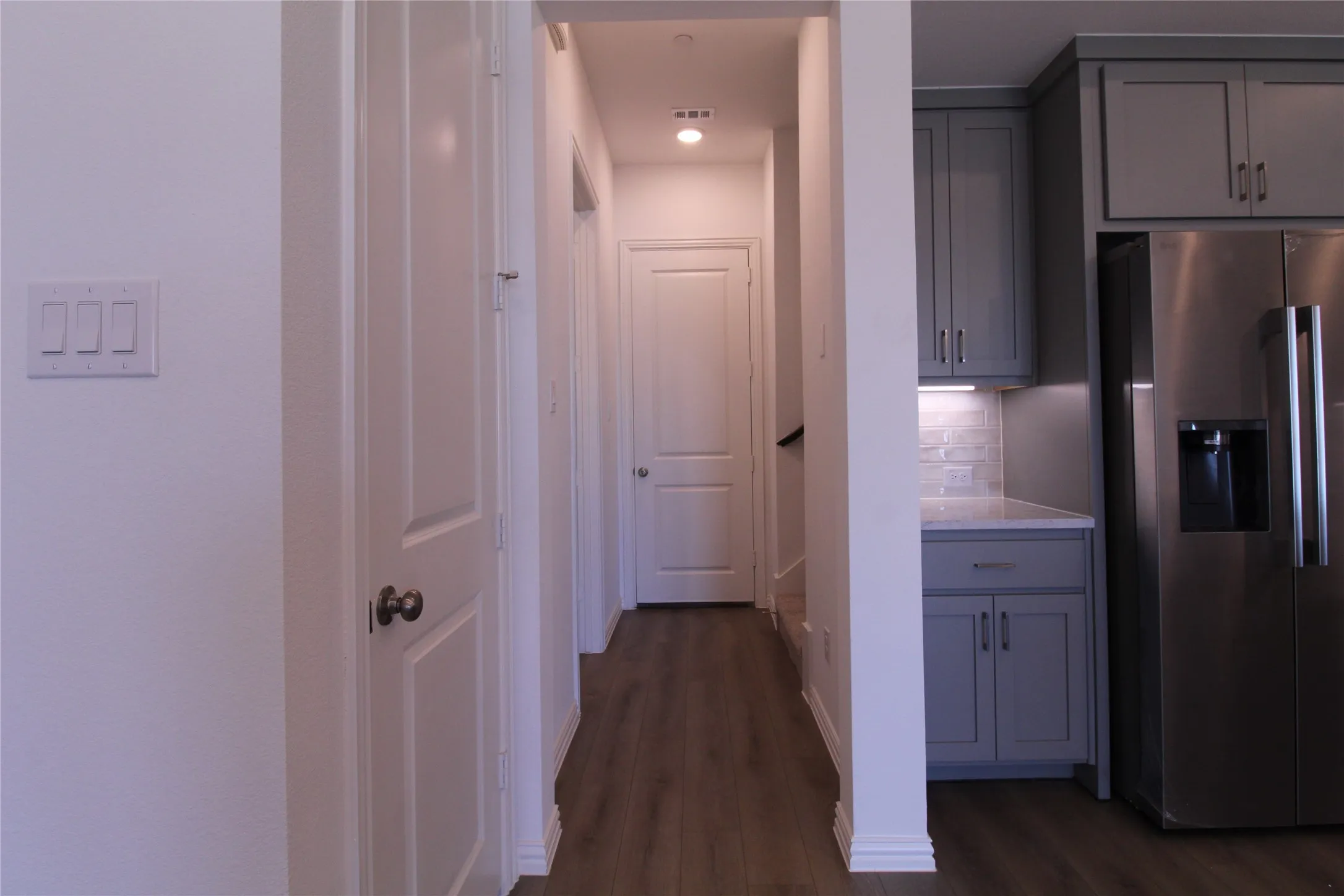 Hallway featuring wood-finish flooring, white panel doors, and recessed lighting