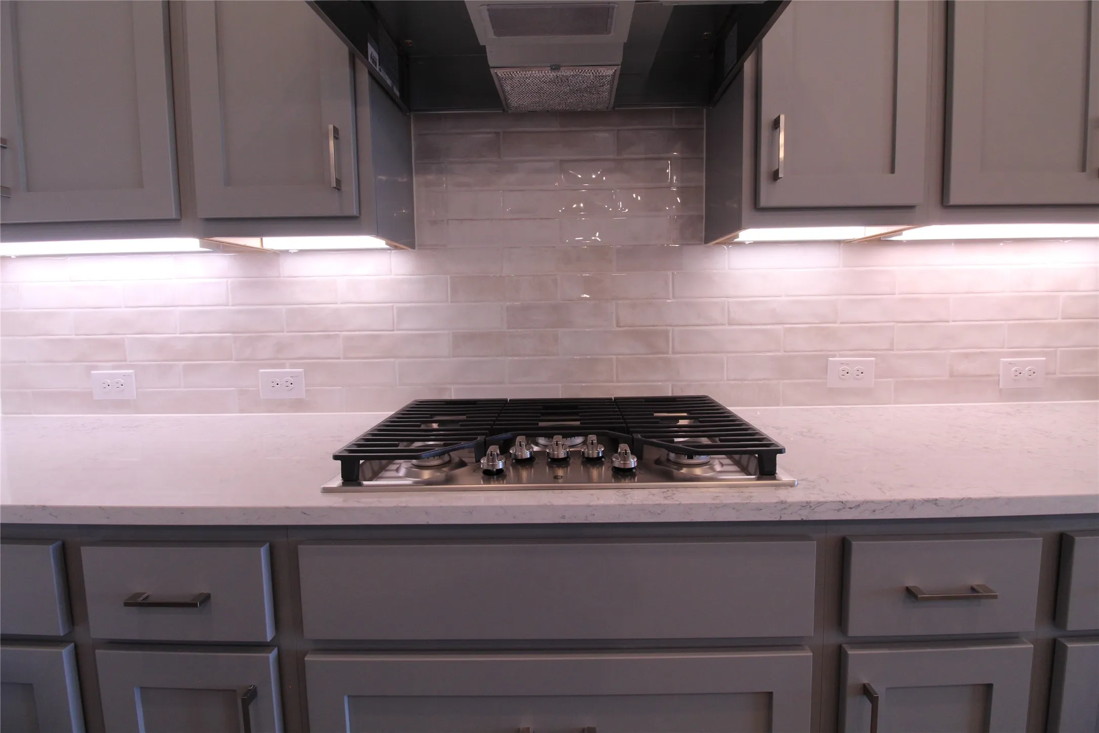Integrated gas cooktop with coordinating range hood