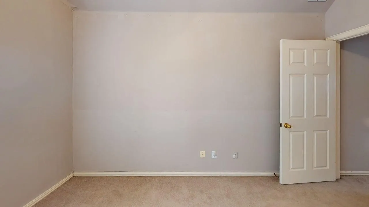Spacious bedroom with neutral wall finishes, carpet flooring, and abundant natural light from recessed ceiling fixtures
