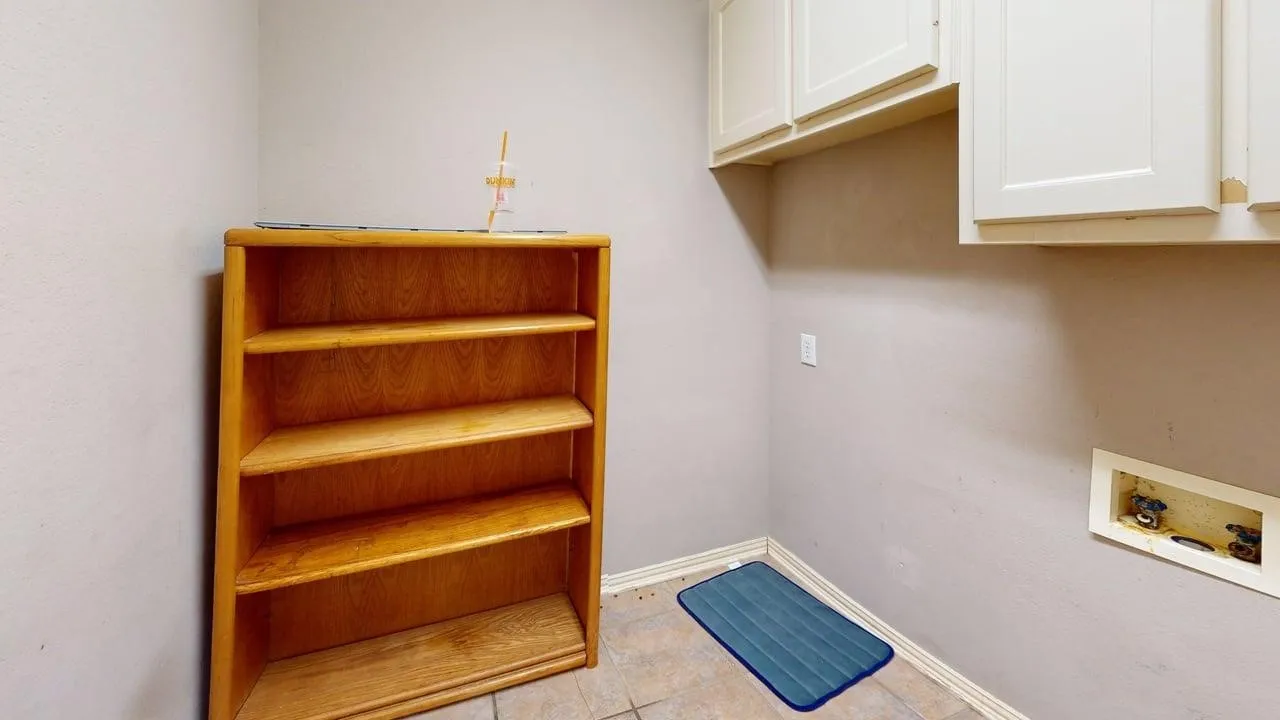 Tile flooring, built-in shelving, and upper cabinetry