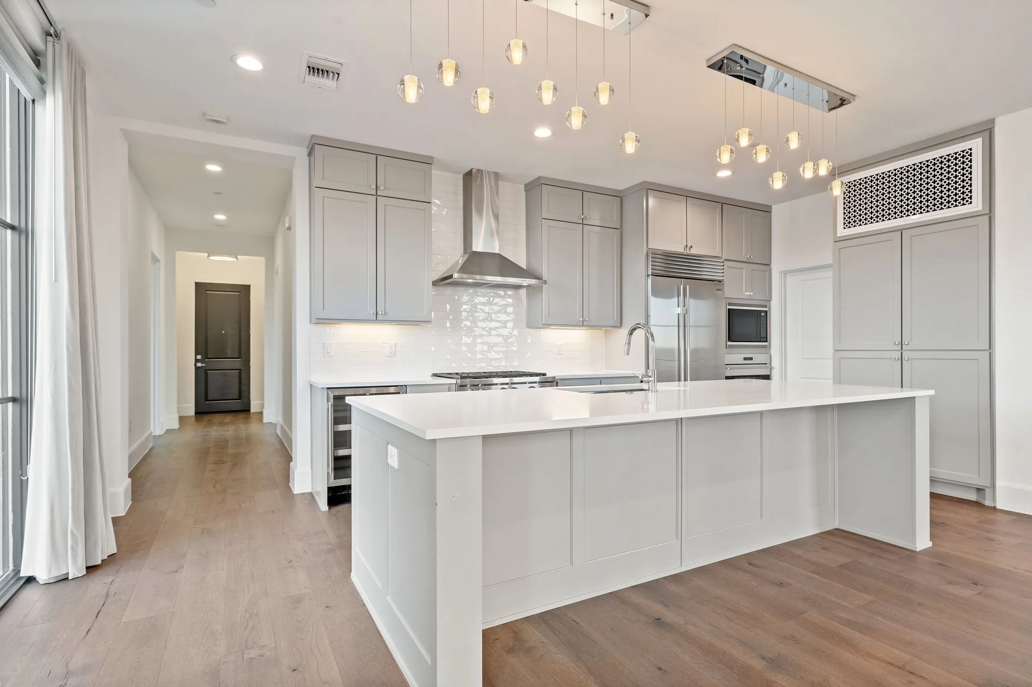 Quartz countertops and an oversized island anchor the beautifully designed kitchen.