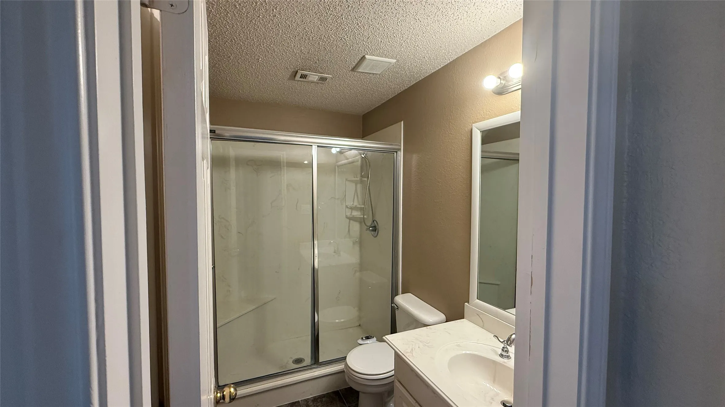 Bathroom featuring a shower with sliding glass doors, built-in shelving, and an integrated bench