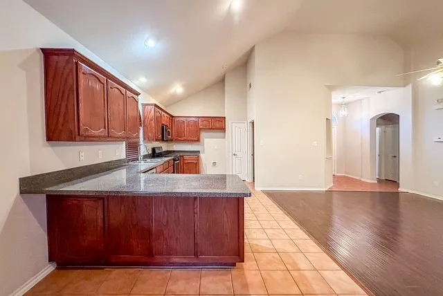 Kitchen featuring wood cabinetry, dark countertops, and stainless steel appliances