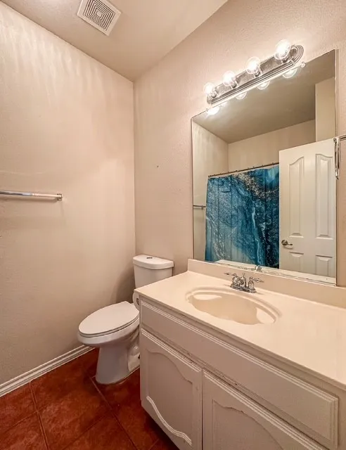 Bathroom featuring a vanity with integrated sink, wall-mounted mirror, and tile flooring