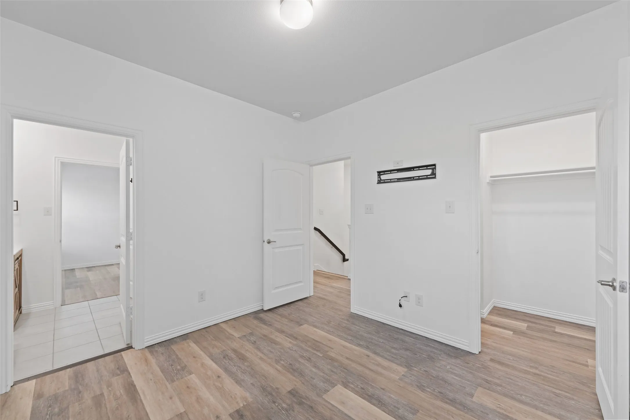 Wood-finish flooring with crisp white walls and ceiling