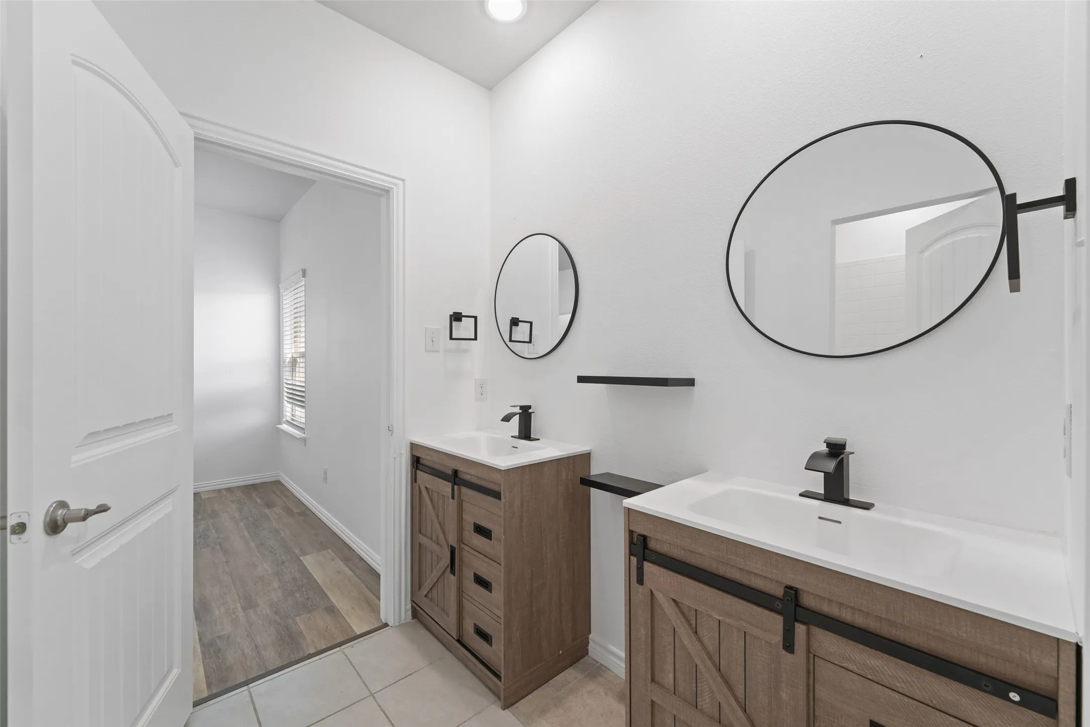 Dual vanity with wood-finish cabinetry and matte black hardware