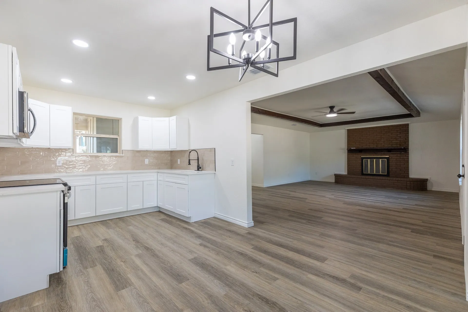 Kitchen featuring white cabinetry, tile backsplash, built-in appliances, and wood-finish flooring