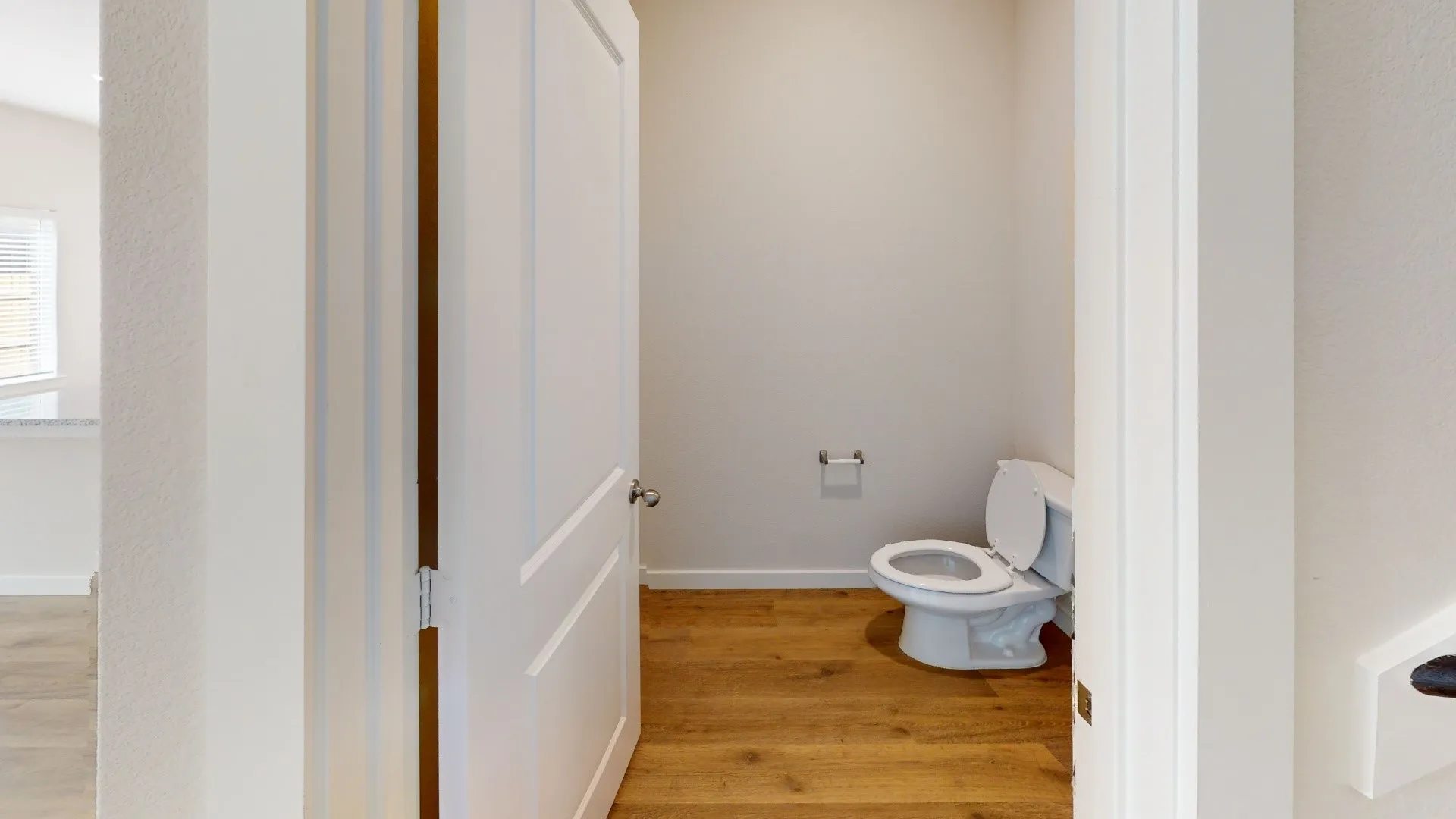 Powder room featuring a toilet and wood-finish flooring