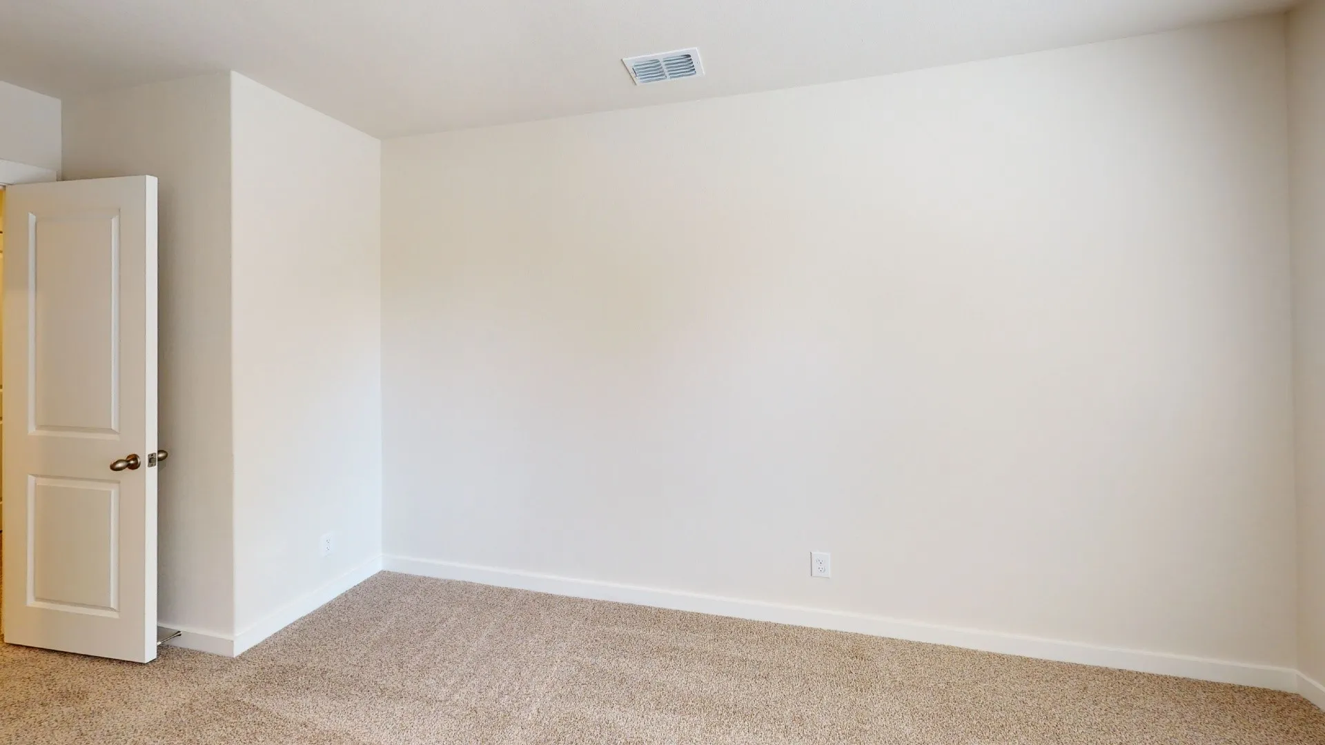 Neutral tone wall color, carpeted flooring, and a two-panel interior door