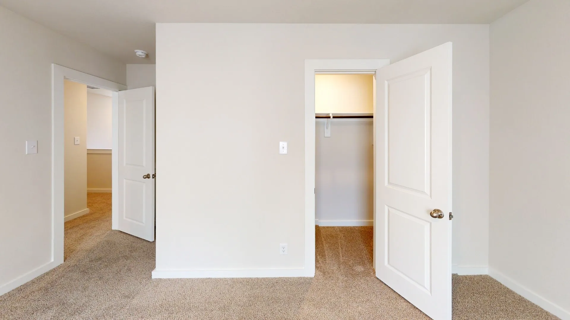 Neutral wall color, paneled interior doors, and carpet flooring