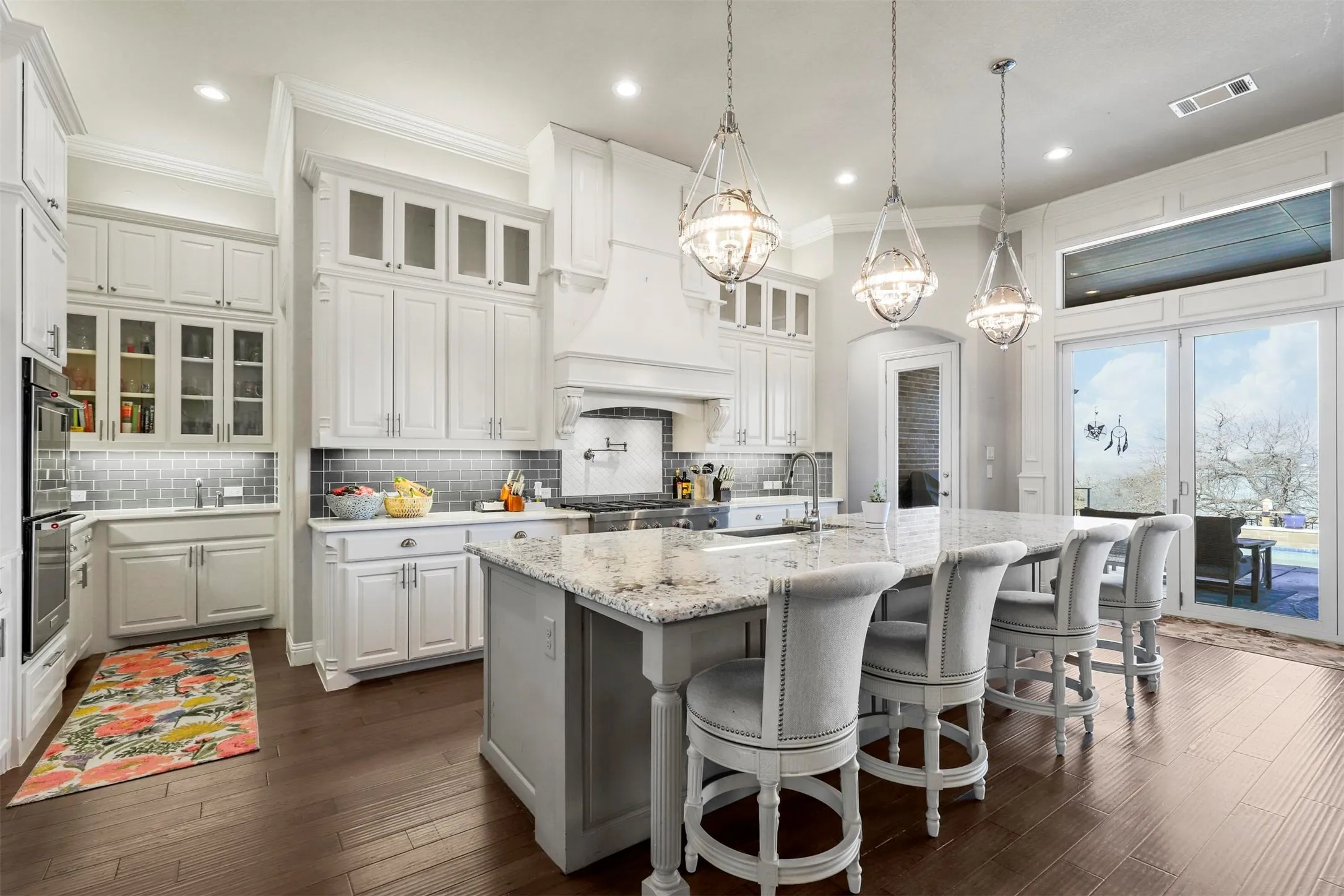 Spacious kitchen with white cabinetry, a large center island featuring a light-toned countertop, and recessed lighting