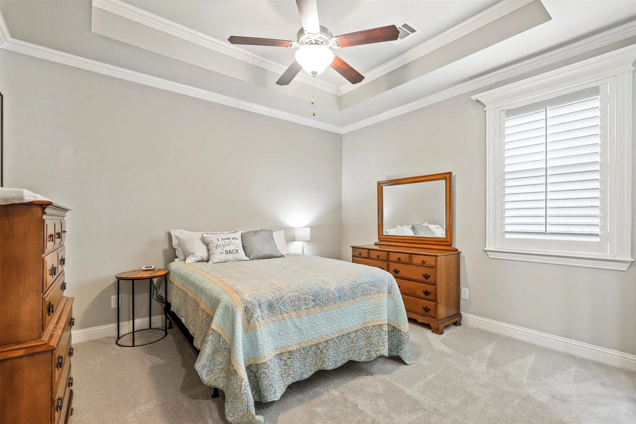 Tray ceiling with crown molding and a ceiling fan