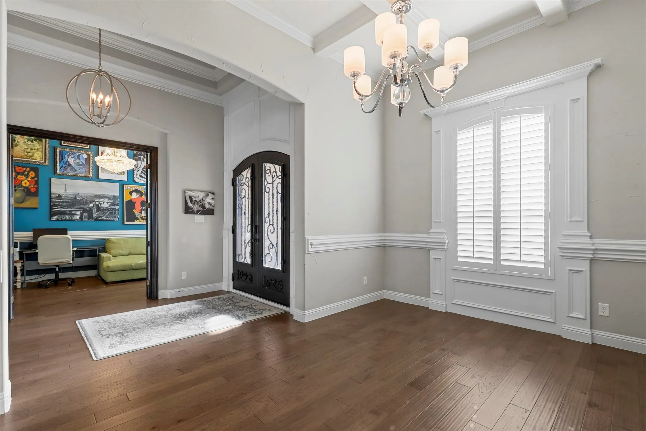 Hardwood-style flooring throughout, custom millwork, coffered ceiling, and an arched entryway