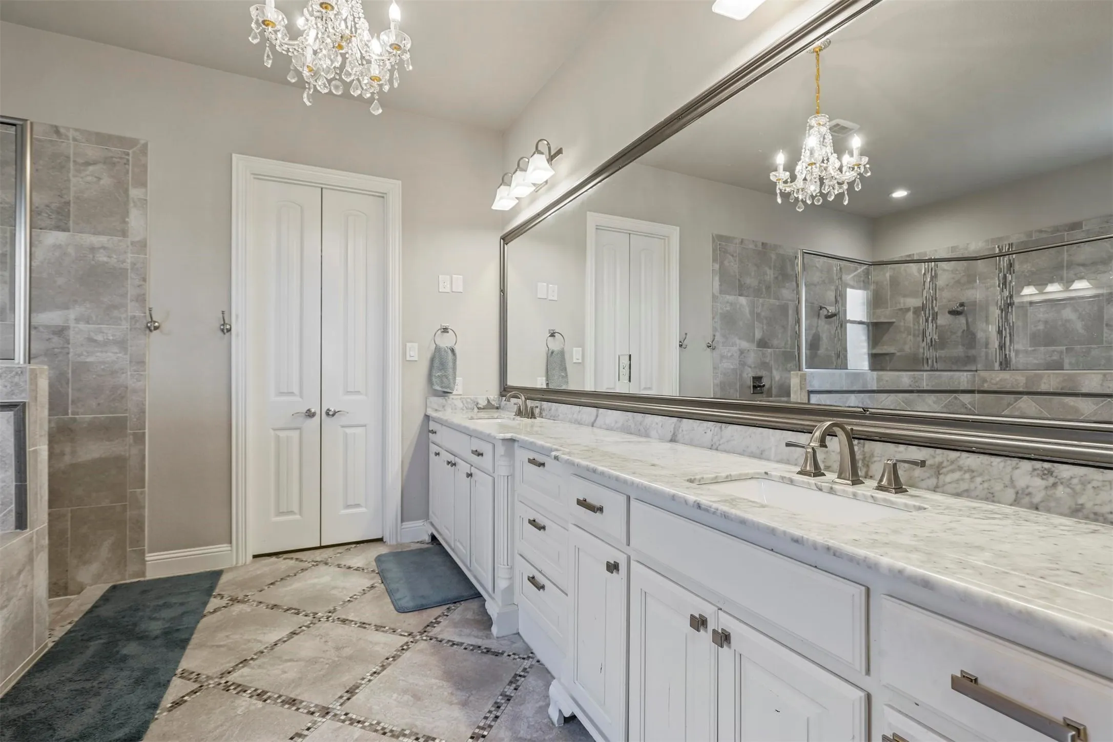 Dual vanity with stone countertops, individual sinks, and brushed nickel hardware