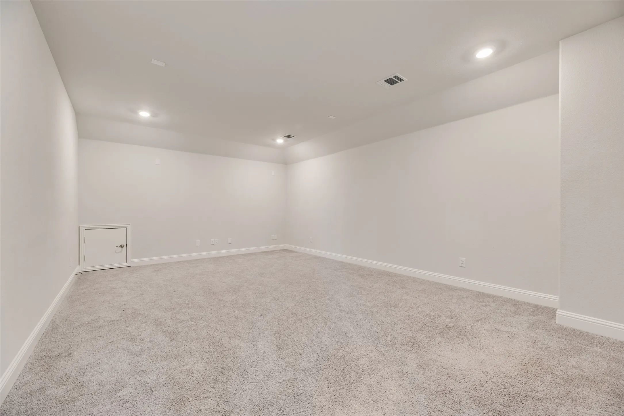 Spacious room featuring light-toned carpeting and recessed ceiling lighting