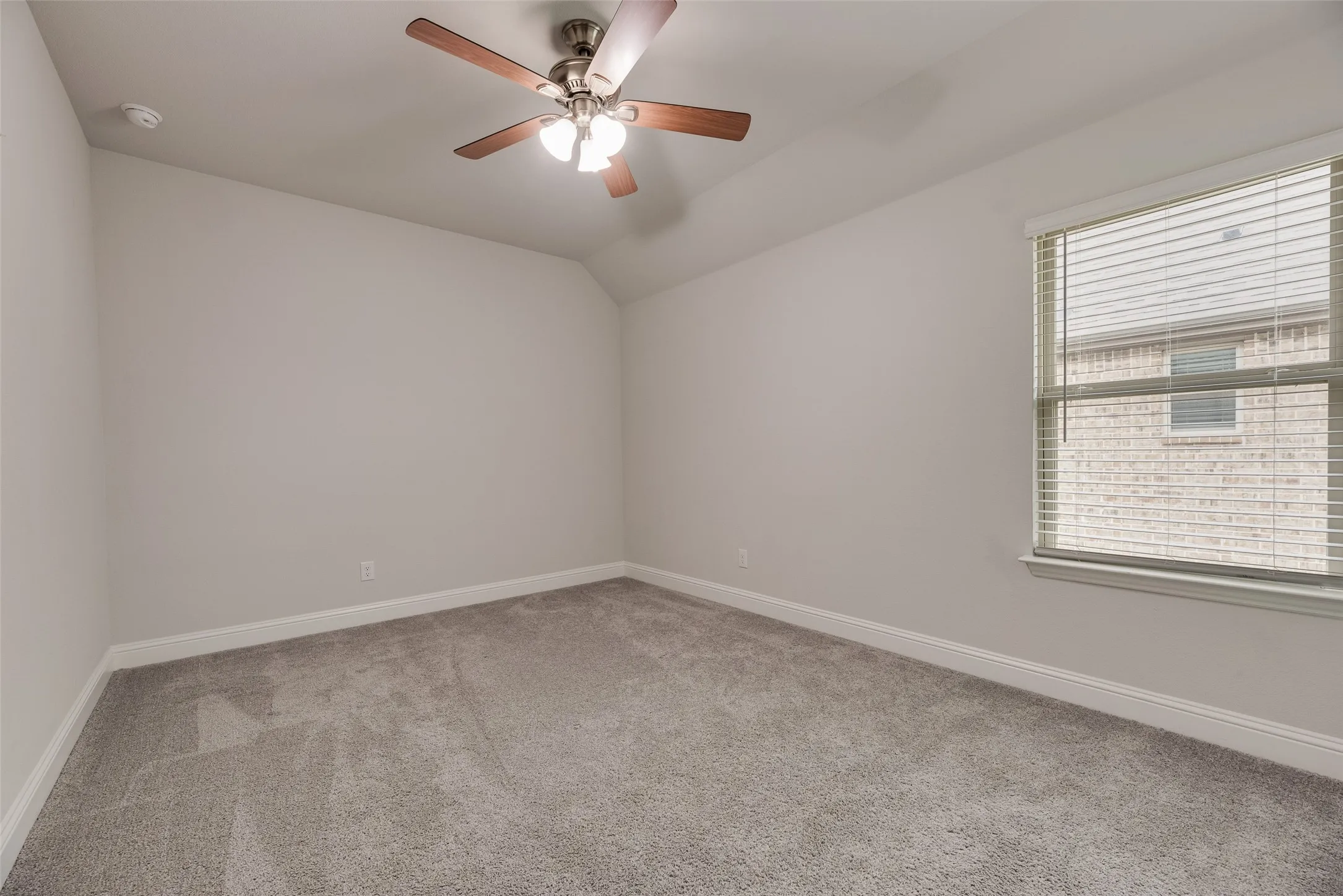 Interior room featuring light gray carpeting, neutral wall paint, and white baseboards