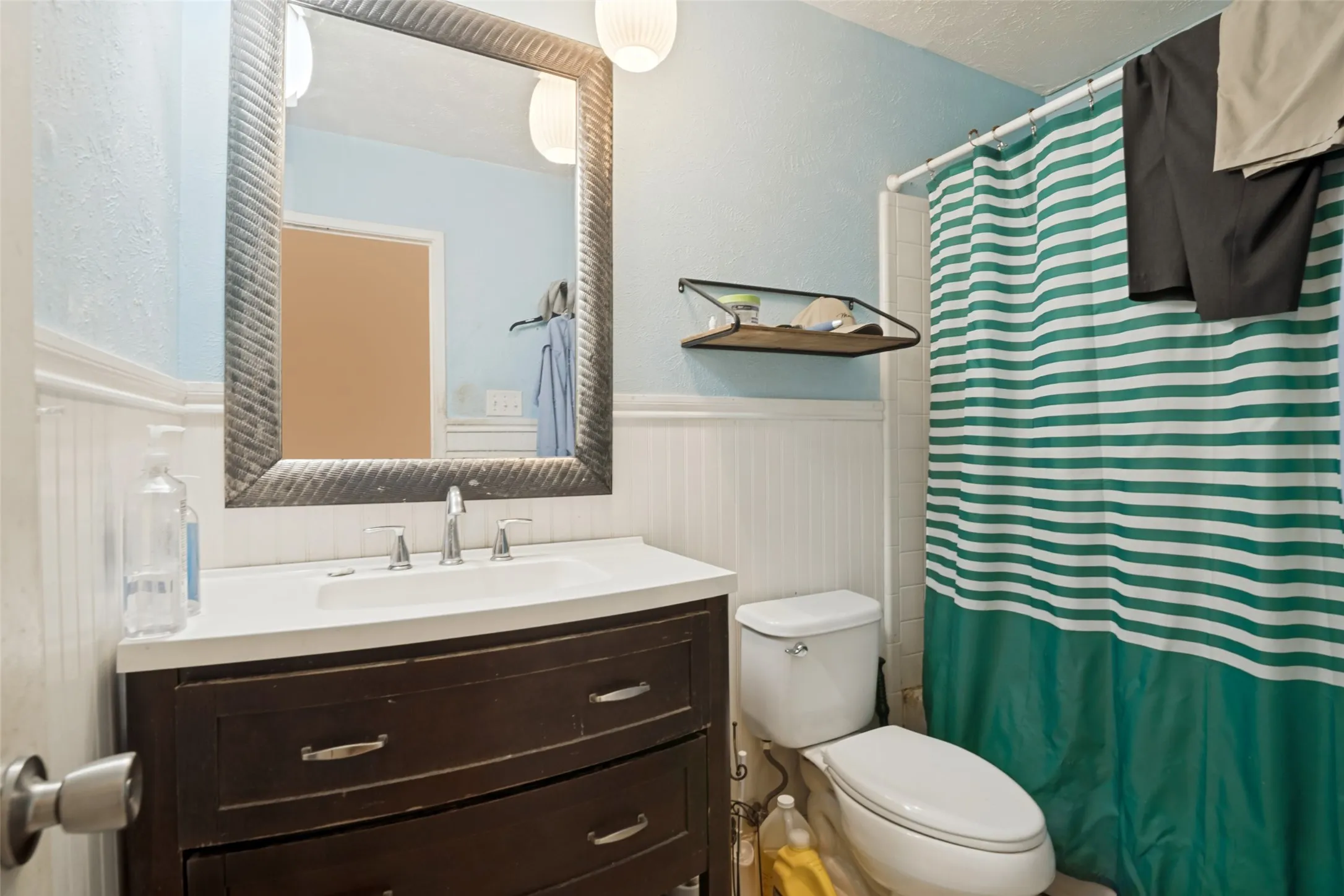 Vanity with a curved front, integrated sink, and chrome fixtures