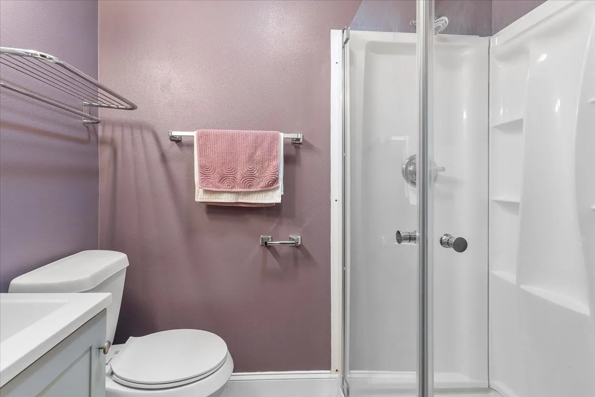 Full glass shower enclosure with chrome hardware, an integrated shower unit, and built-in shelving