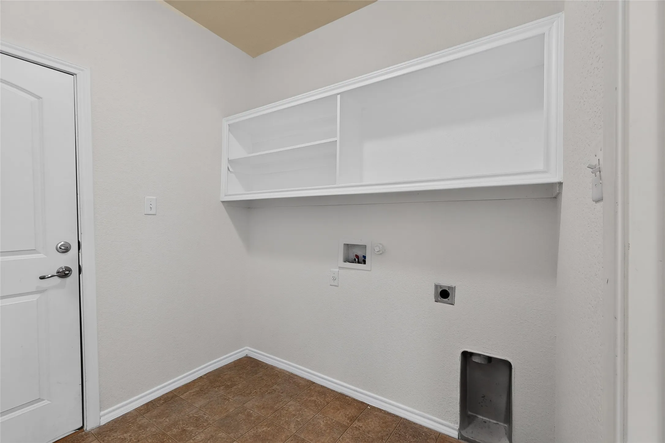 Recessed wall shelving, overhead built-in cabinetry, durable flooring, and pre-installed appliance hookups