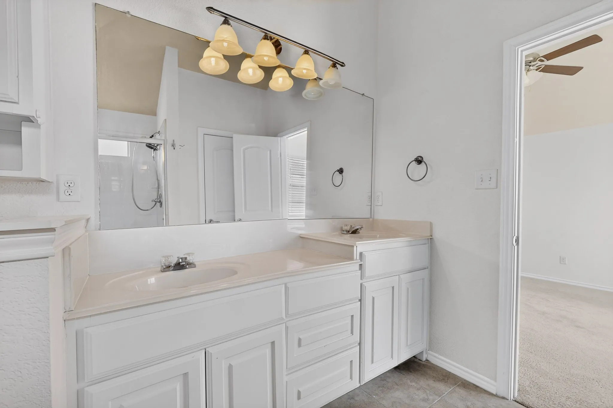 Dual sink vanity with white cabinetry and integrated sinks
