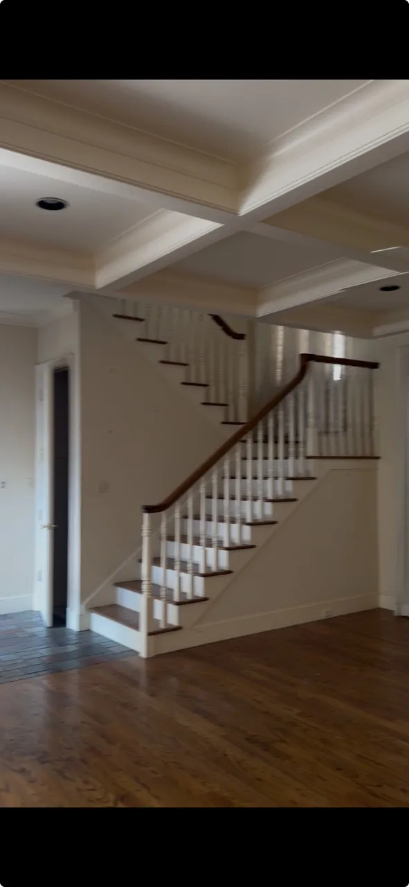 Hardwood flooring, coffered ceiling, recessed lighting, and a back staircase with wood-finish handrails