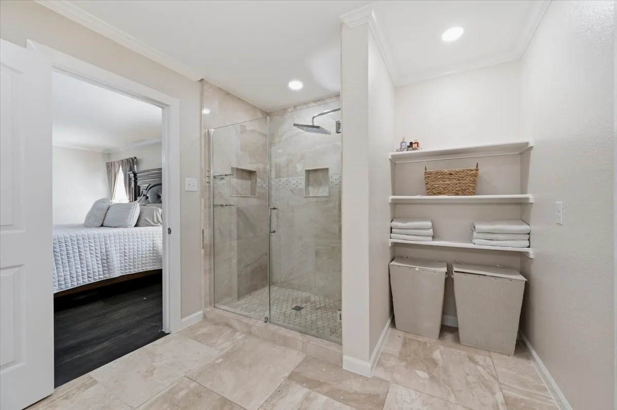 Walk-in shower with glass enclosure, tiled walls, and built-in niches