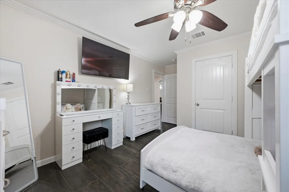 Dark-toned wood-finish flooring complements light-toned walls and crown molding