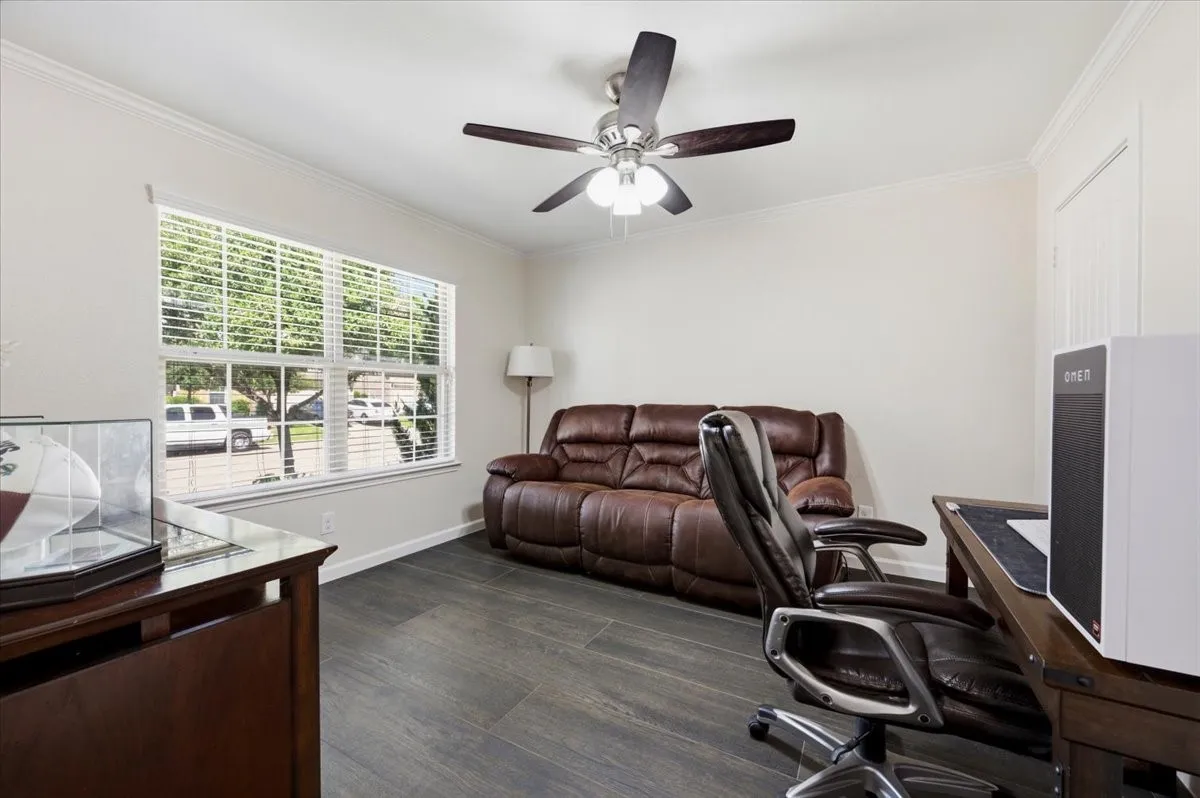 Wood-finish flooring throughout, complemented by crown molding and a multi-pane window