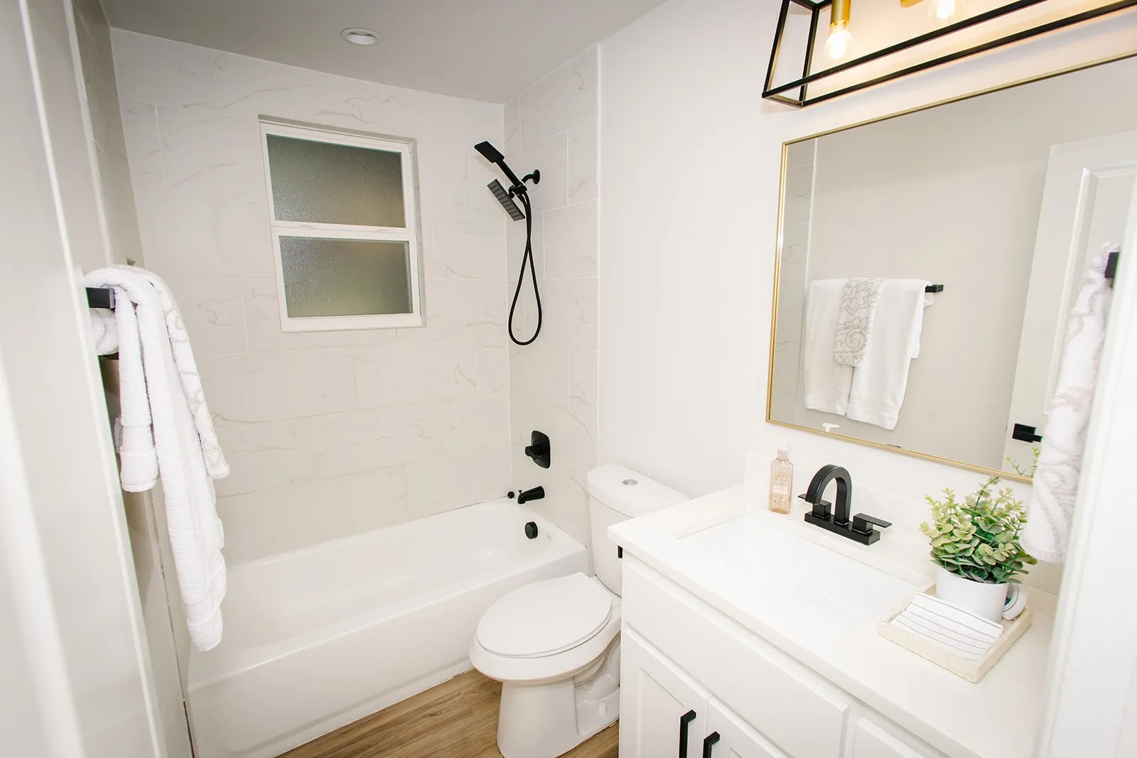 Guest bathroom White vanity with dark hardware, a rectangular undermount sink, and a single-handle faucet