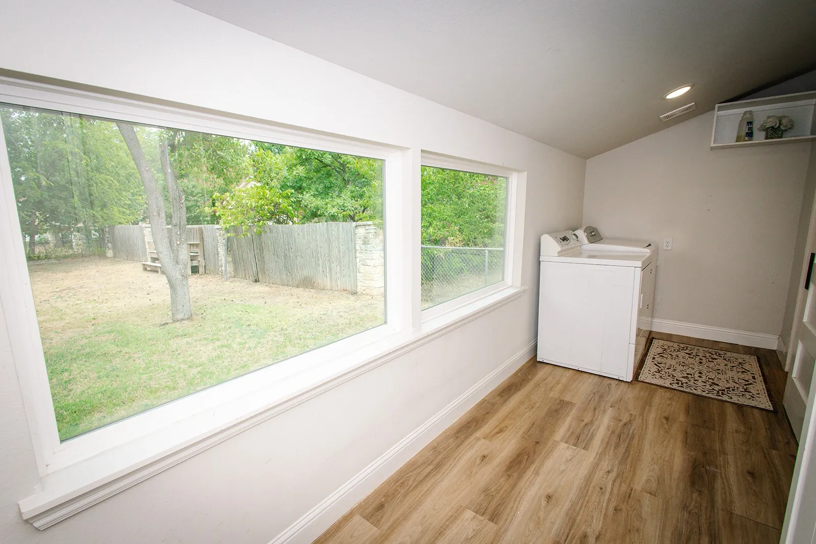 Separate fenced area Expansive backyard featuring a mature tree, chain-link fencing, and a dark slat fence