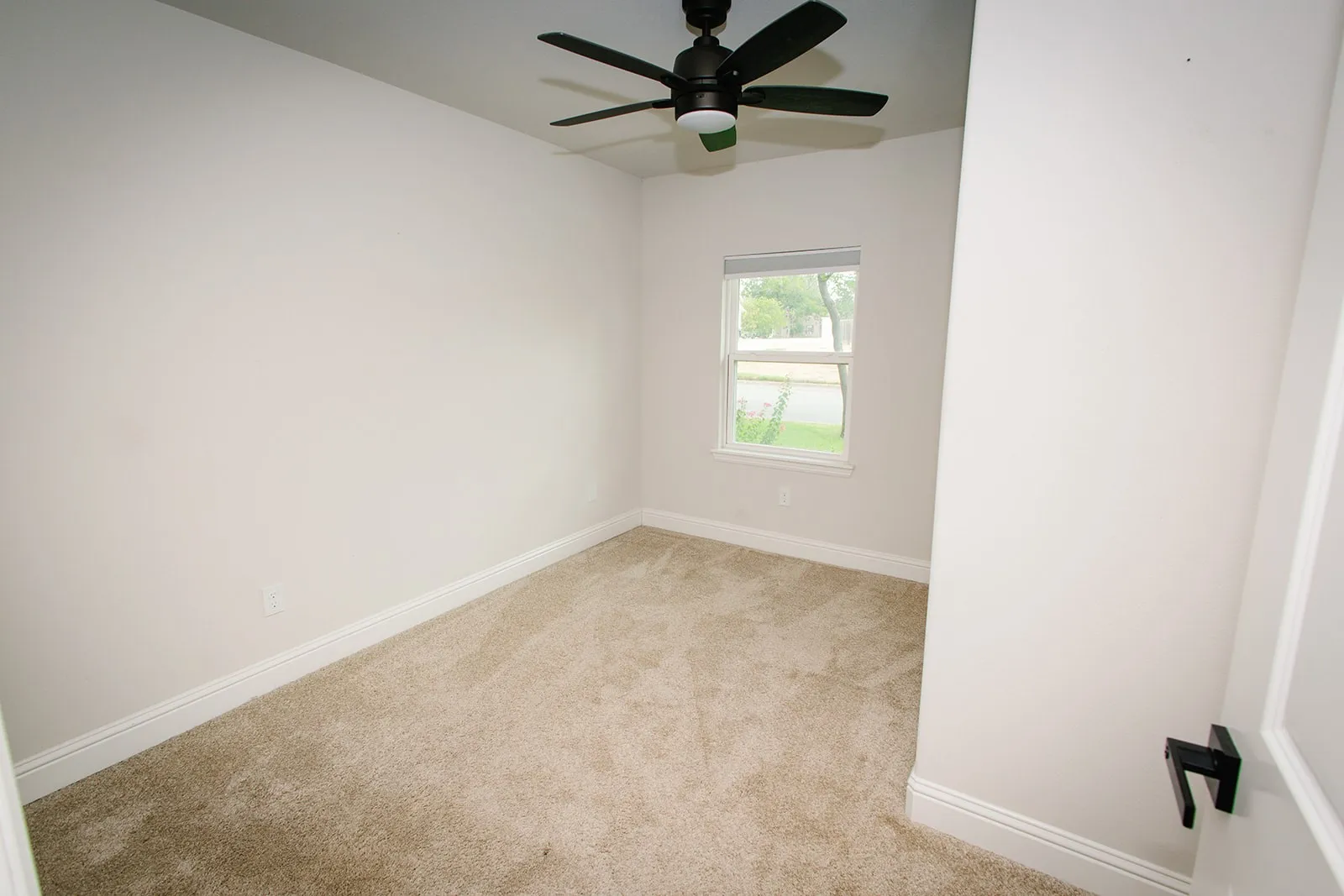 Neutral wall paint, carpeted flooring, window with exterior exposure, and ceiling fan with lighting