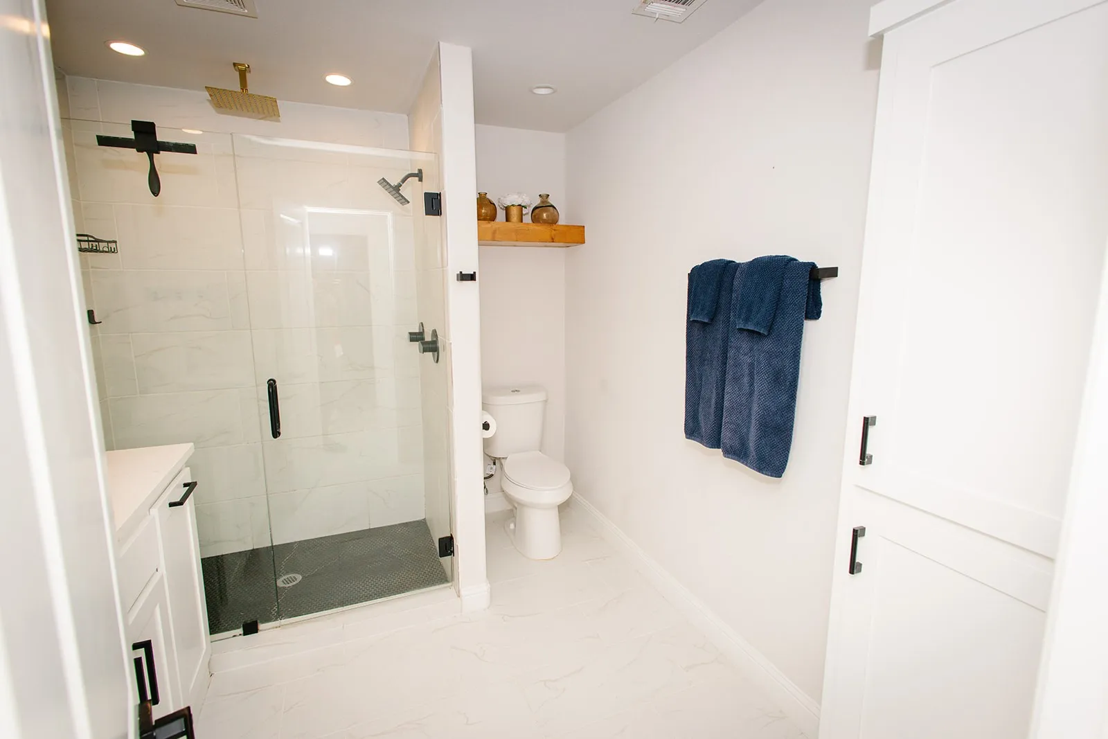 Master bath Glass-enclosed shower with black fixtures and a gold-toned rain showerhead