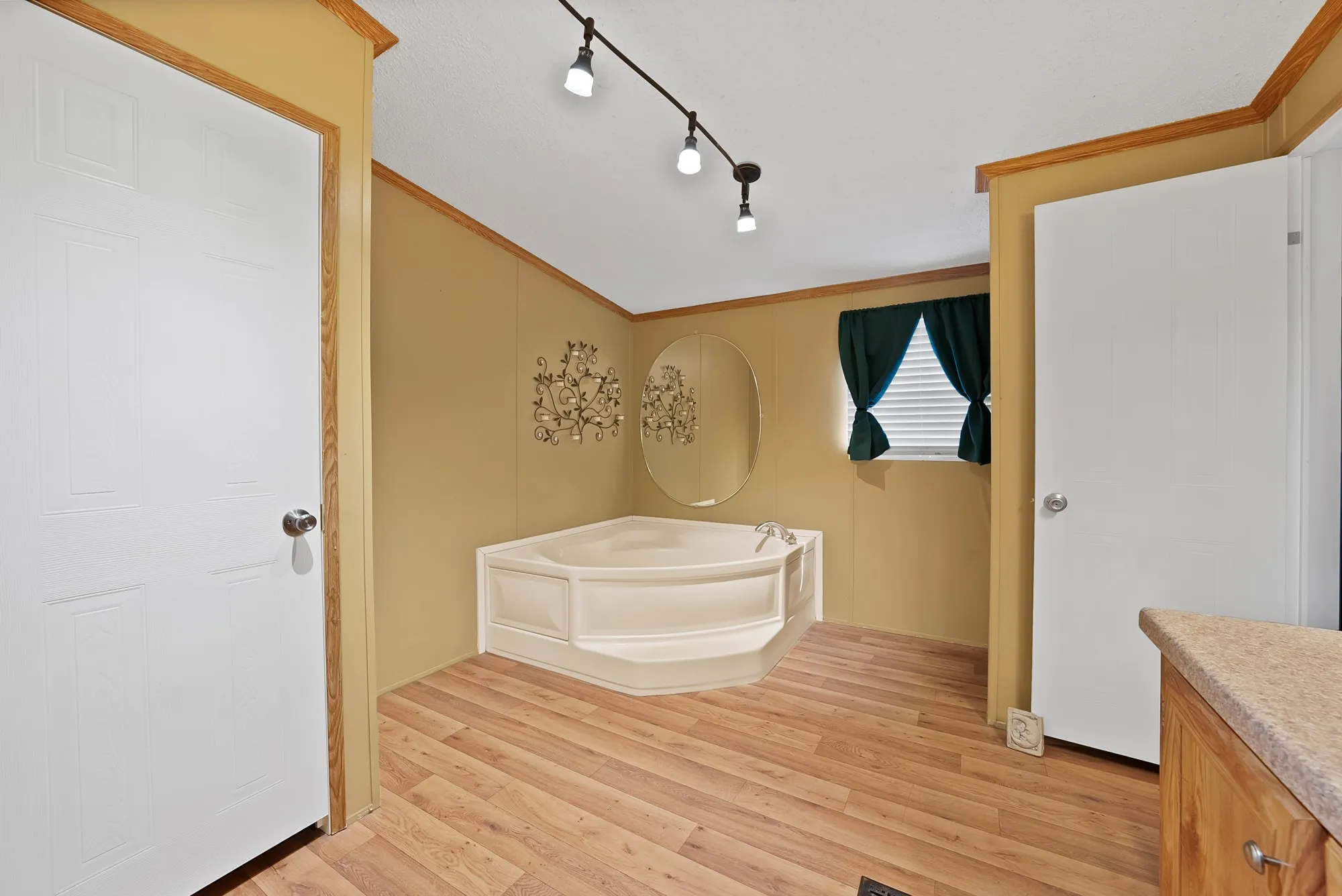 Corner soaking tub with wood-finish flooring