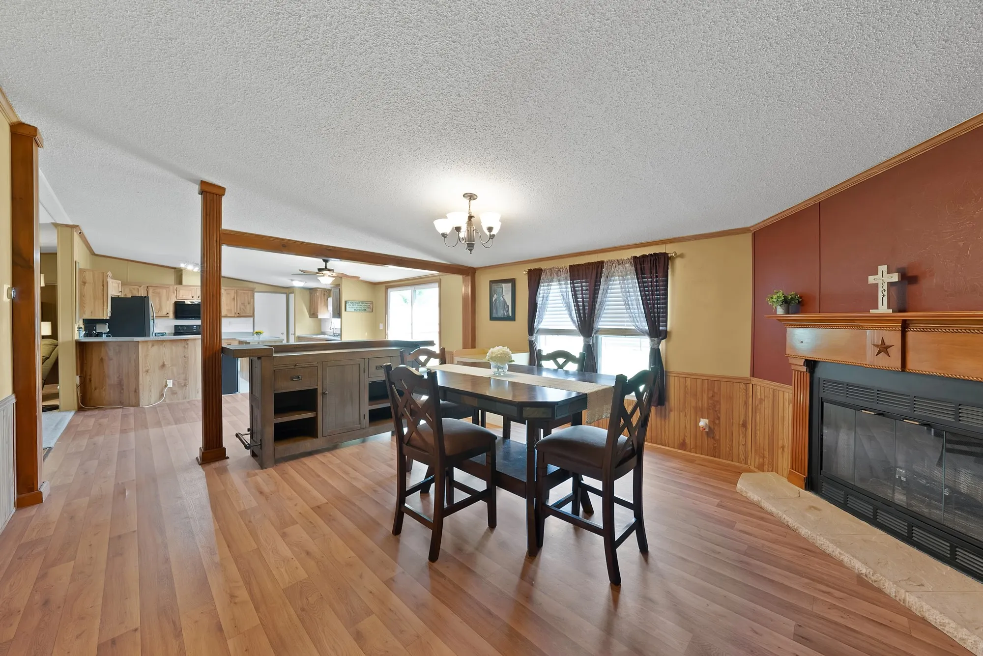Wood-finish flooring throughout, with a built-in fireplace featuring a stone hearth and wood mantel