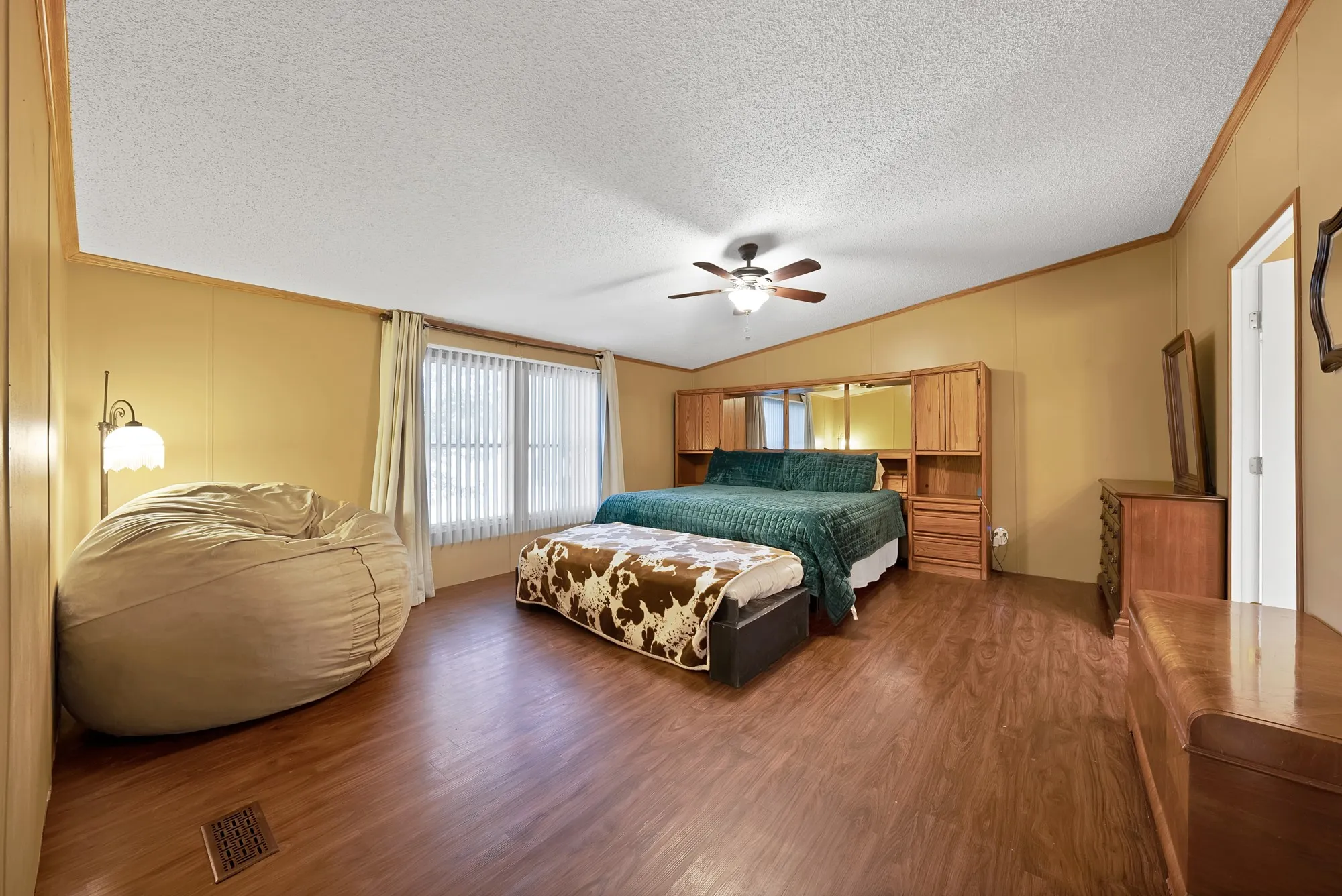 Wood-finish flooring throughout, complemented by a ceiling fan with integrated lighting