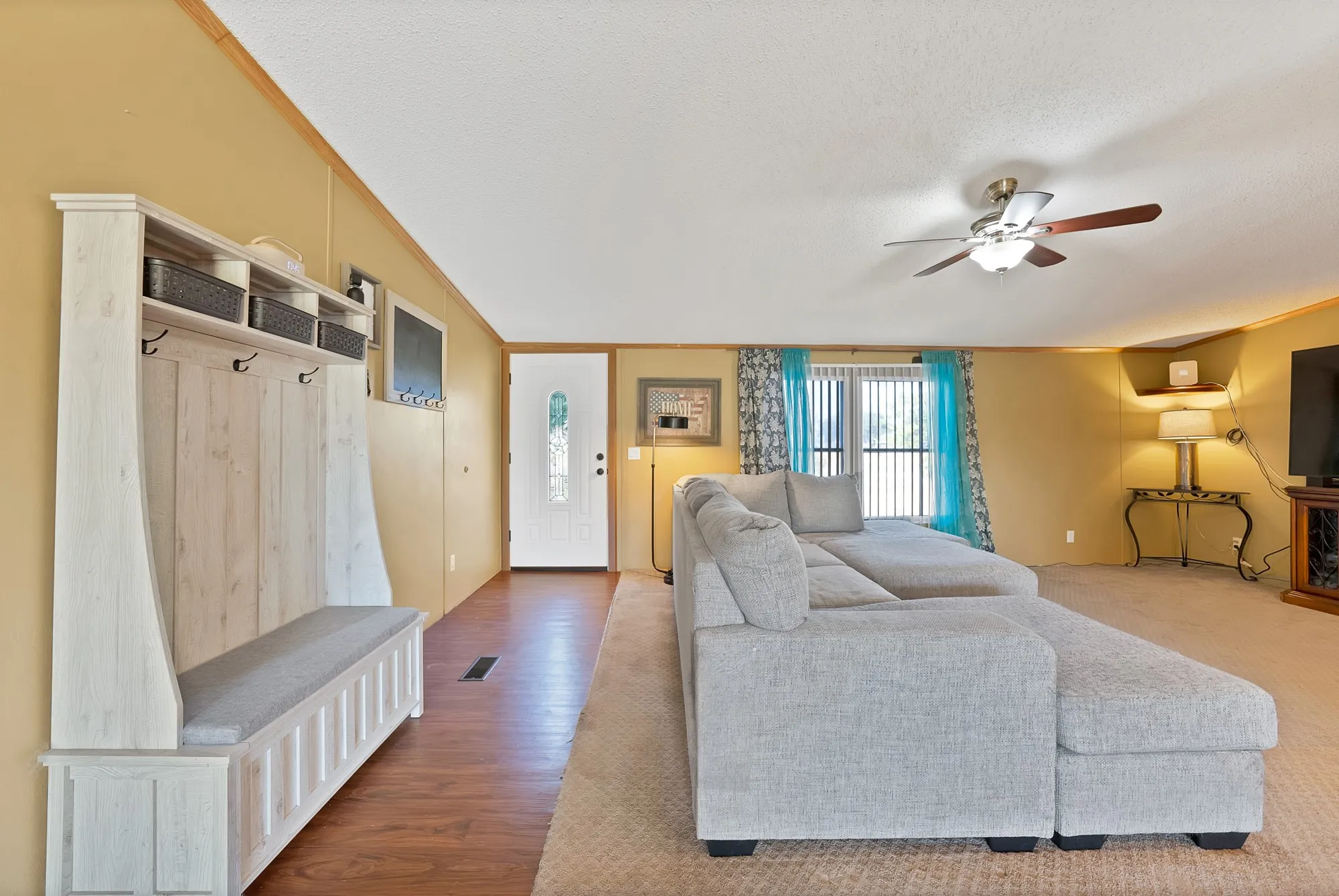 Wood-finish flooring in the entryway, complemented by a built-in hall tree with seating