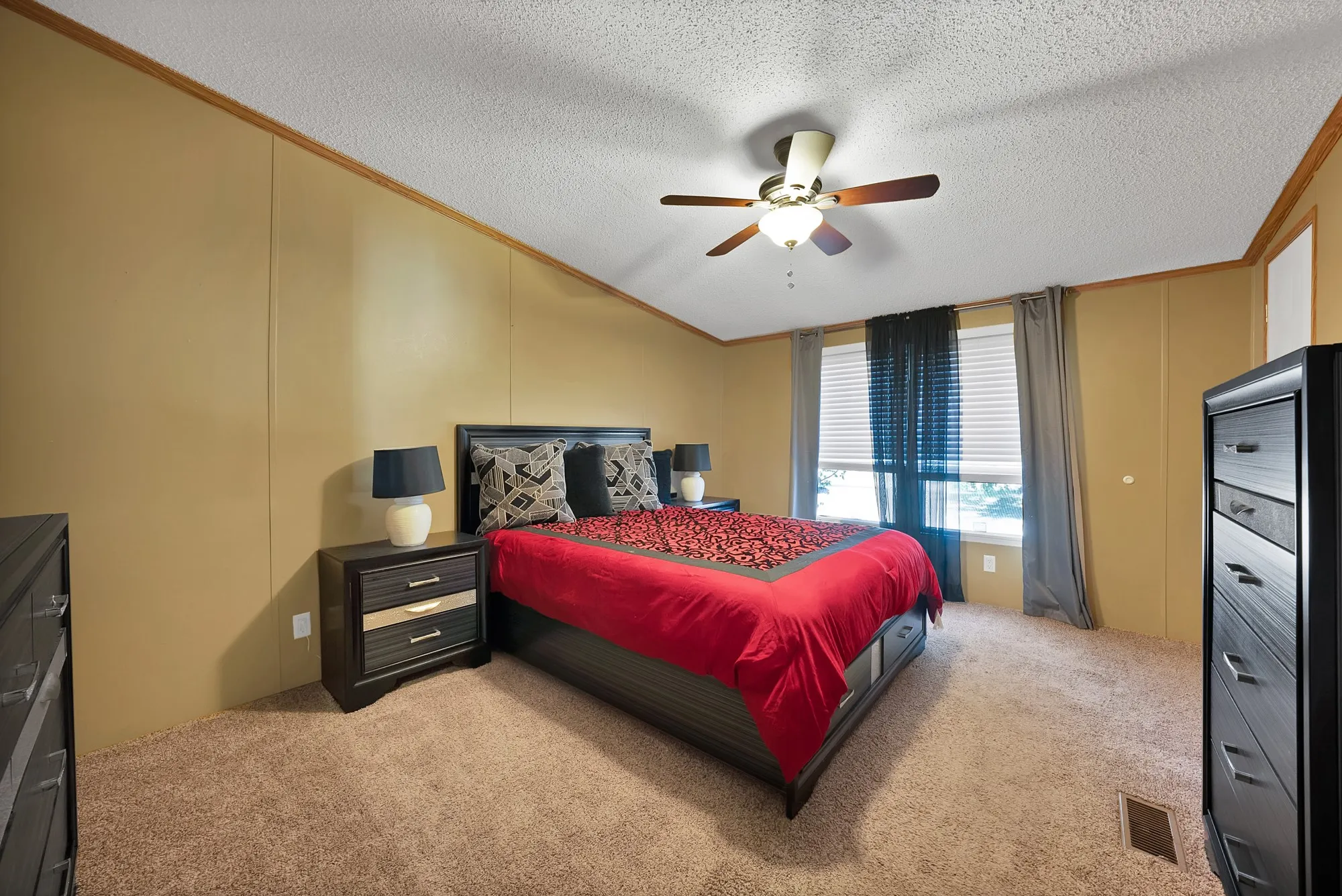 Carpeted flooring, vaulted ceiling, ceiling fan with light fixture, and window with blinds