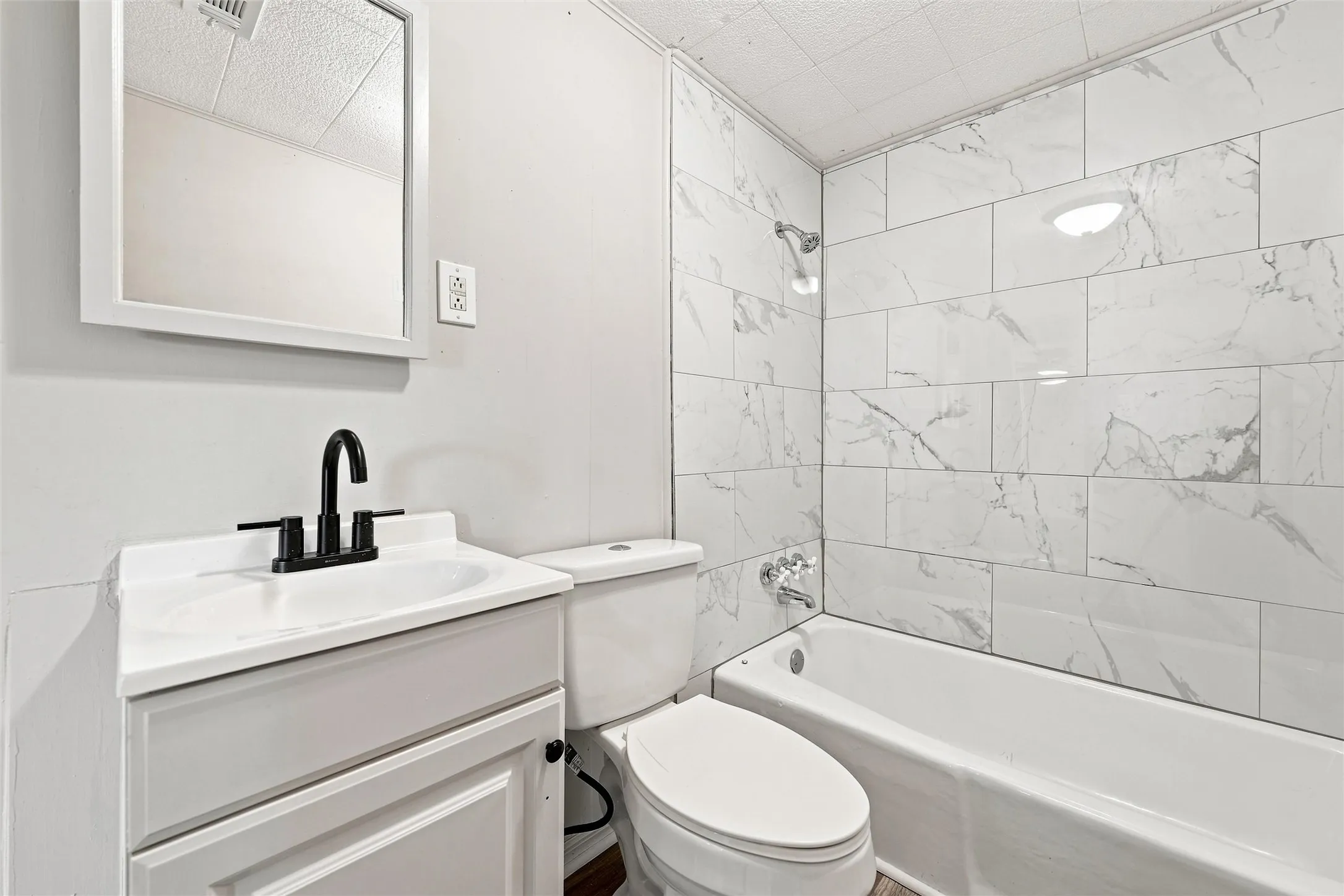 White vanity with an integrated sink and a matte black faucet