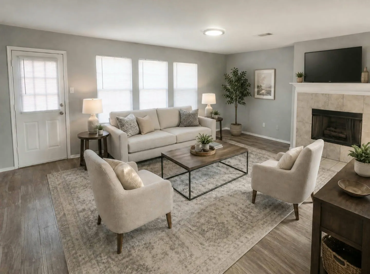 Bright natural lighting, wood-like tile flooring, fireplace with tile surround, and multiple windows