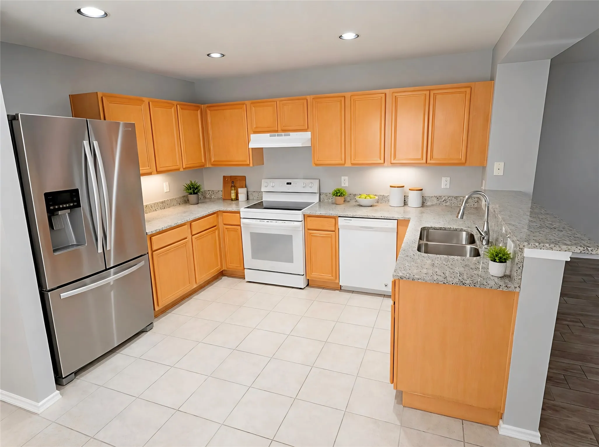 Kitchen featuring light wood cabinetry, granite countertops and backsplashes, glass-top range, and tiled flooring (Fridge not included)